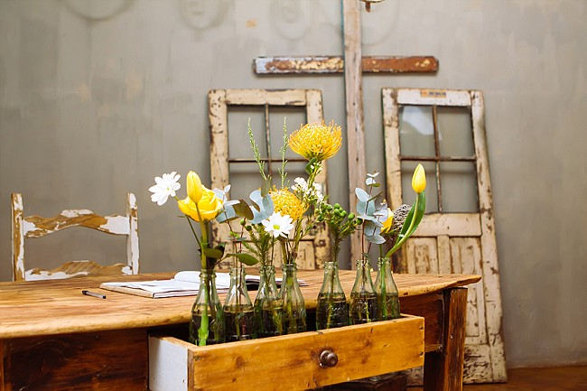 Vintage bottles with single flowers in wooden crate // Yellow and Grey DIY Vintage Wedding // Miracles Photo