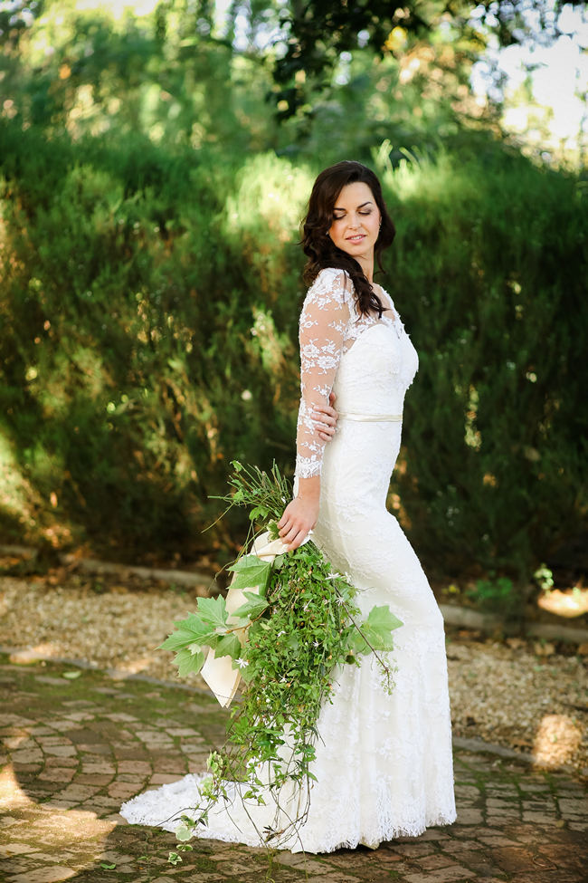 Long, lace sleeved wedding dress with cascade bouquet made of leaves for a Rustic Garden Picnic Wedding // Nikki Meyer Photography