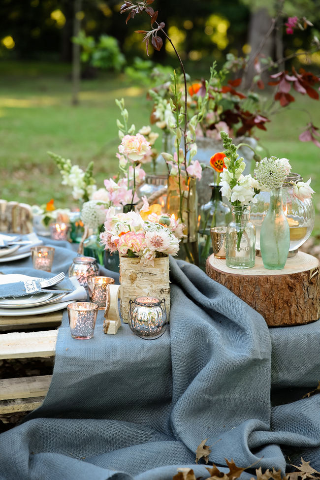 A pretty pallet picnic table using grey hessian burlap runner, filled with rustic decor elements, mercury votives, wood slabs and peach blooms in mix and match vases. Rustic Garden Picnic Wedding // Nikki Meyer Photography