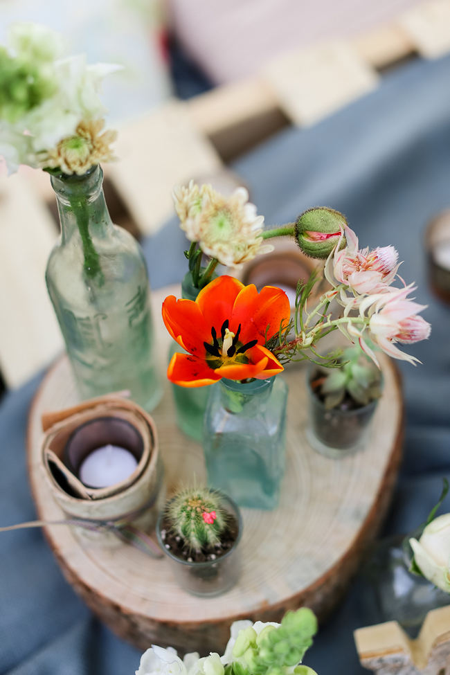 Wood slices with birch wrapped votives and single stem tulip in mix and match bottles // Rustic Garden Picnic Wedding // Nikki Meyer Photography