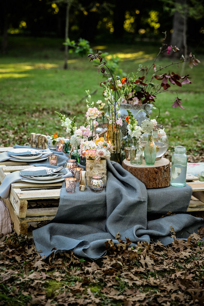 A pretty pallet picnic table using grey hessian burlap runner, filled with rustic decor elements, mercury votives, wood slabs and peach blooms in mix and match vases. Rustic Garden Picnic Wedding // Nikki Meyer Photography