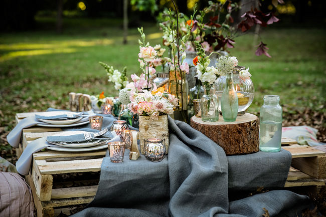 A pretty pallet picnic table using grey hessian burlap runner, filled with rustic decor elements, mercury votives, wood slabs and peach blooms in mix and match vases. Rustic Garden Picnic Wedding // Nikki Meyer Photography