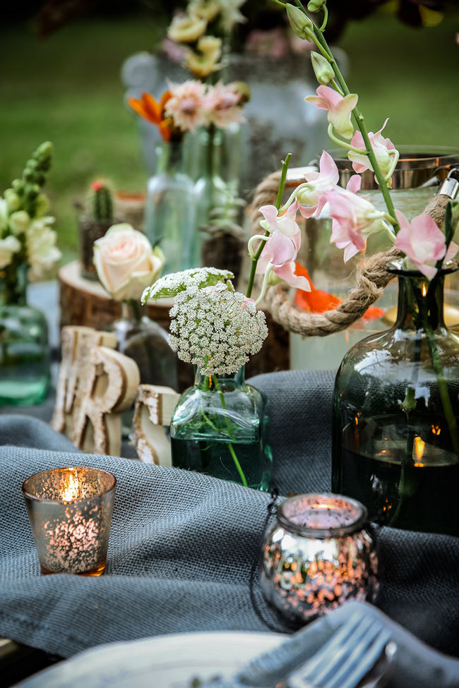 A pretty pallet picnic table using grey hessian burlap runner, filled with rustic decor elements, mercury votives, wood slabs and peach blooms in mix and match vases. Rustic Garden Picnic Wedding // Nikki Meyer Photography