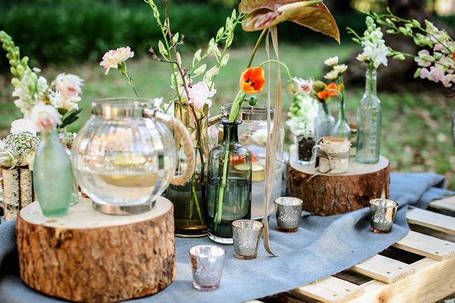 A pretty pallet picnic table using grey hessian burlap runner, filled with rustic decor elements, mercury votives, wood slabs and peach blooms in mix and match vases. Rustic Garden Picnic Wedding // Nikki Meyer Photography