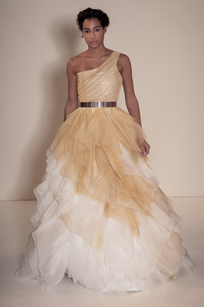 Asymmetrical off the shoulder wedding dress in gold and white with gold belt and layered tulle skirt. Della Giovanna Wedding Dresses 