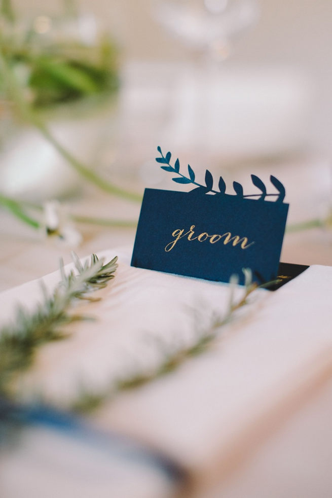 Navy blue bride and groom place cards with leaf patterning. 