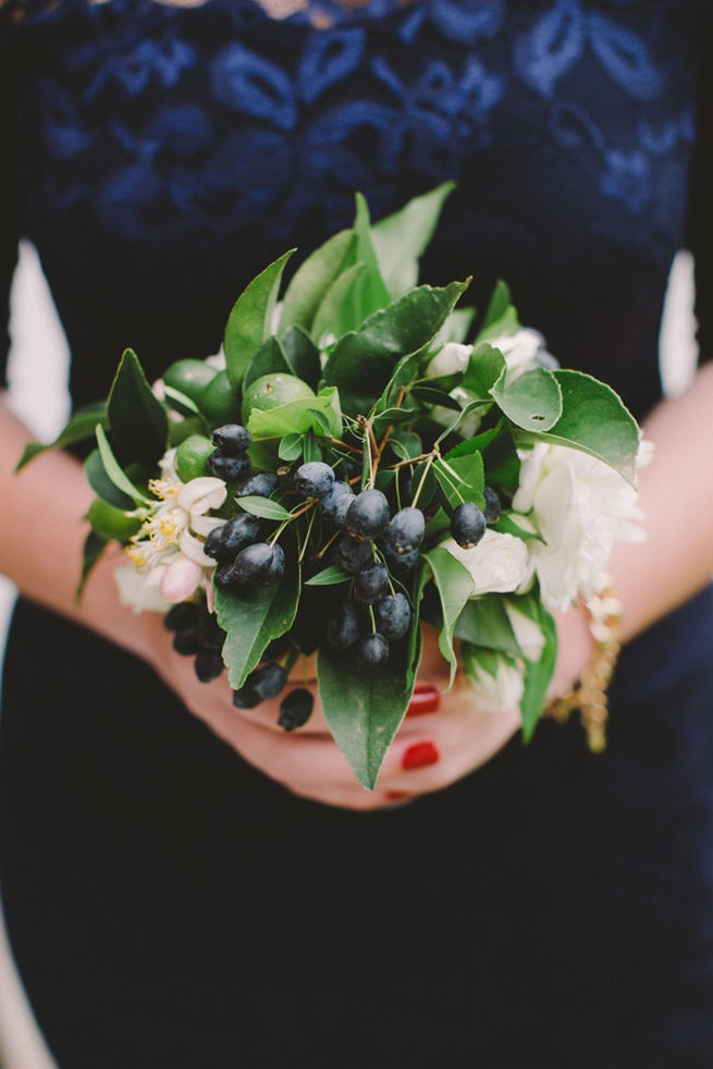 Green, white and navy bridesmaids bouquet with greens and blue berries wrapped in navy ribbon