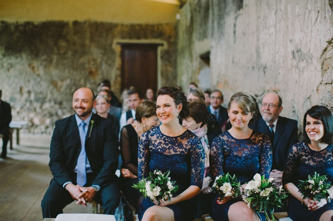 Bridesmaids wearing navy lace sleeved gowns