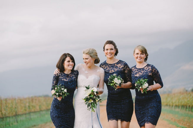  Bridesmaids in short navy dresses with long lace sleeves