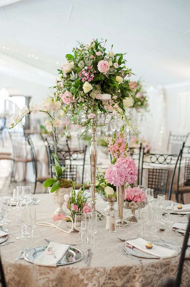 Blush and pink wedding flowers in silver urns and vases on wedding reception tables: hydrangea, pink and cream roses, lisanthius and leatherleaf ferns . So pretty for a spring wedding // D’amor Photography