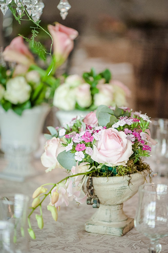 Blush and pink wedding flowers in silver urns and vases on wedding reception tables: hydrangea, roses, lisanthius and leatherleaf ferns // D’amor Photography