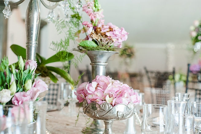 Blush and pink wedding flowers in silver urns and vases on wedding reception tables: hydrangea, roses, lisanthius and leatherleaf ferns // D’amor Photography