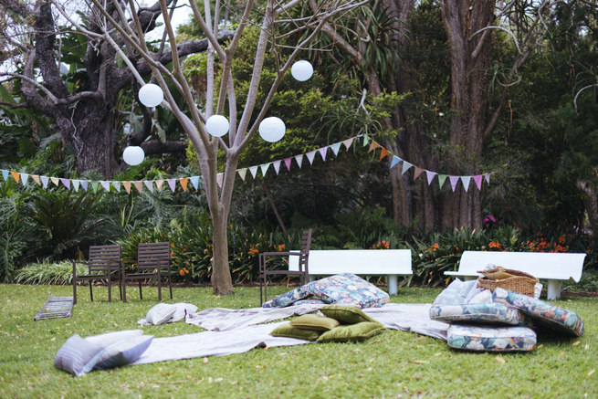 Bunting, paper lanterns and Wedding picnic area with blankets and cushions // Succulent Garden Wedding // Claire Thomson Photography