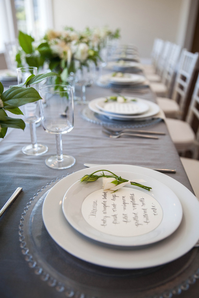 Hand calligraphed menu by Steele My Hear, place setting on clear glass charger and elegant fresh florals by Angel's Petals. Elegant Gray Blue Nautical Wedding by Rachel Capil Photography and Lindsay Lauren Events