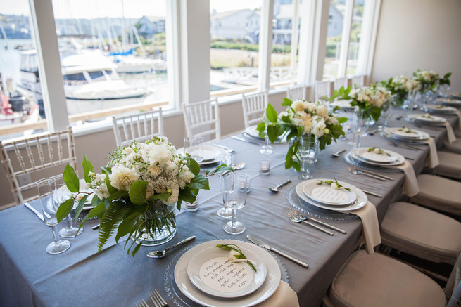  Grey and white tablescape using place settings on clear glass chargers, linens by Napa Valley Linens and elegant fresh florals by Angel's Petals. Elegant Gray Blue Nautical Wedding by Rachel Capil Photography and Lindsay Lauren Events