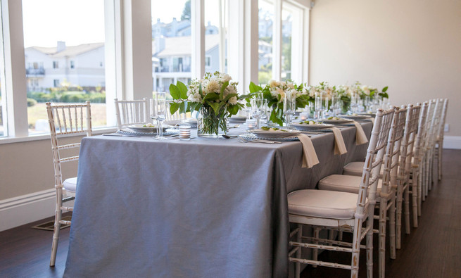  Grey and white tablescape using place settings on clear glass chargers, linens by Napa Valley Linens and elegant fresh florals by Angel's Petals. Elegant Gray Blue Nautical Wedding by Rachel Capil Photography and Lindsay Lauren Events