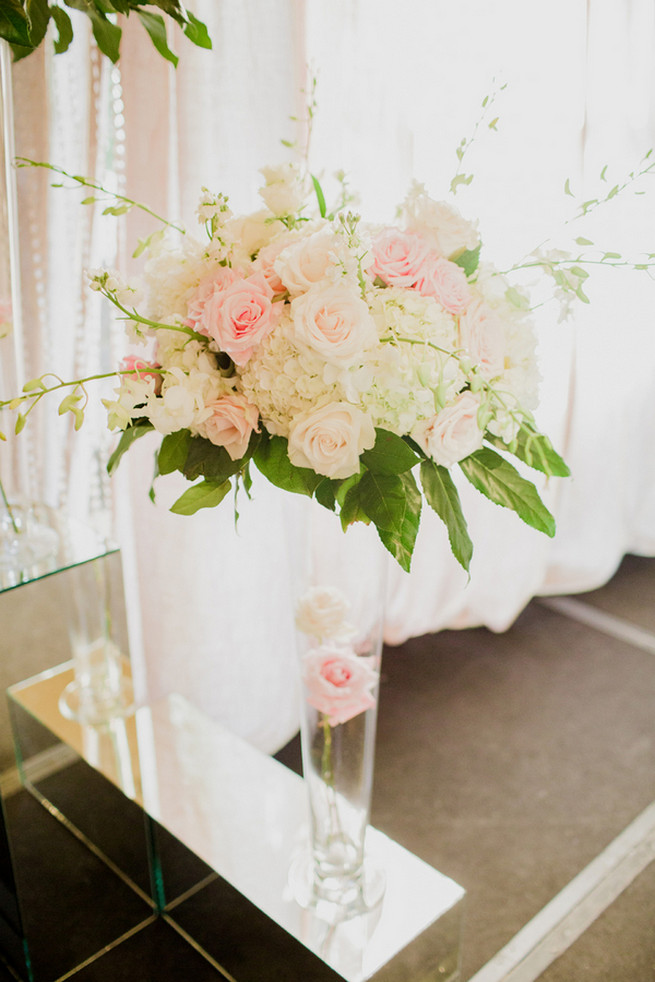 Chic Wedding reception florals of white hydrangea, blush roses, white roses and green fillers with white blossoms. 