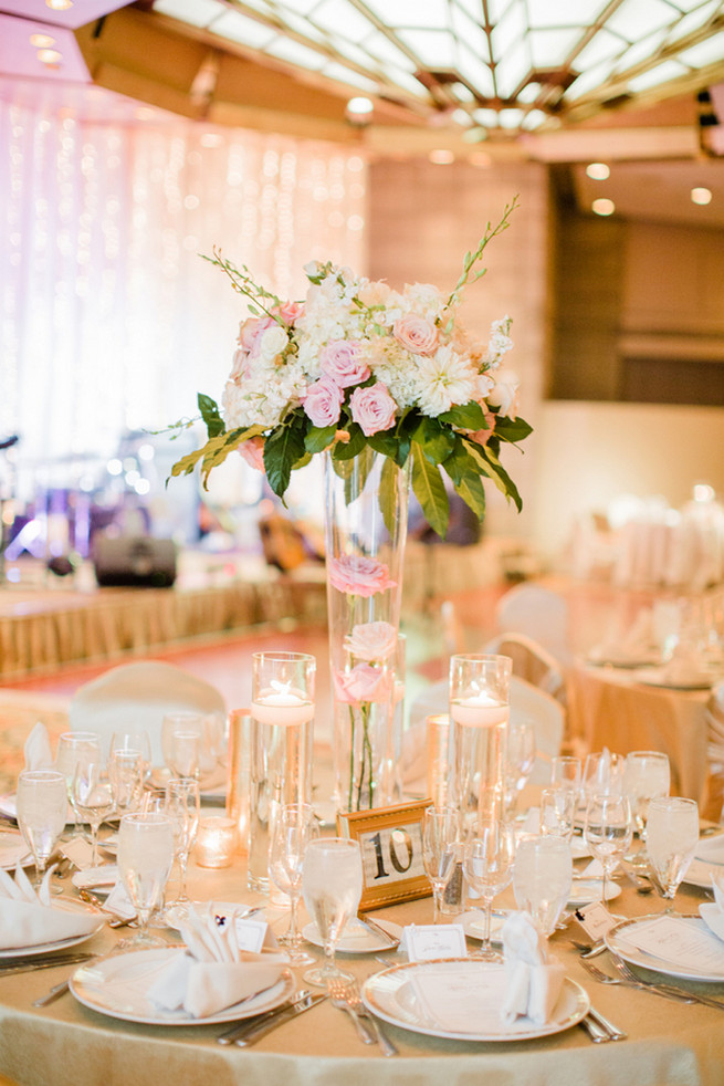 Chic Wedding reception florals of white hydrangea, blush roses, white roses and green fillers with white blossoms. 