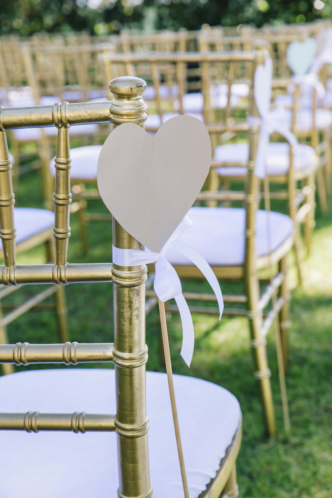 Gold Tiffany chairs with gold DIY hearts. White and Gold DIY Chevron Wedding, South Africa, by Claire Thomson Photography