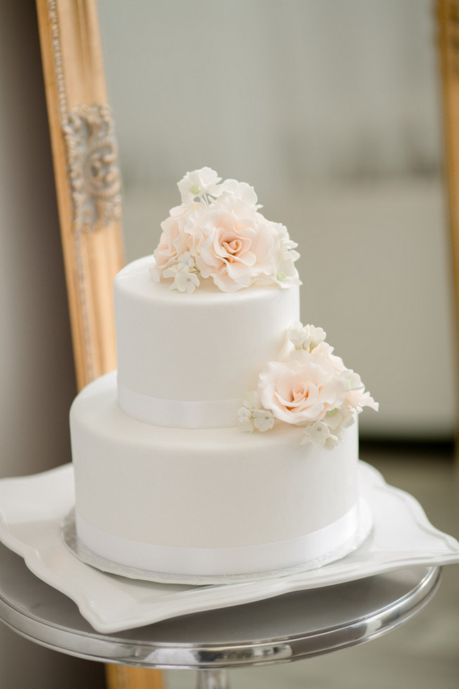 Stunning white cake with flower topper and detail. White on White Glamorous Wedding Ideas by ENV Photography. Cake by The Art of Cake.