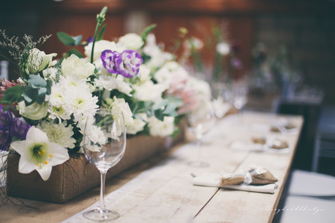 Farm style blooms. Rustic table decor with wood slabs, vintage bottles, lace and single stem roses.