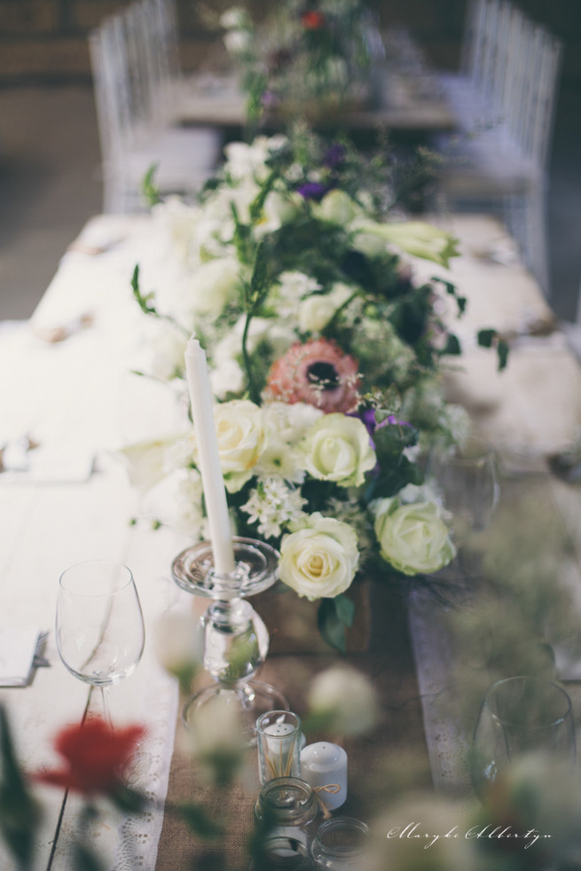 Farm style blooms. Rustic table decor with wood slabs, vintage bottles, lace and single stem roses.