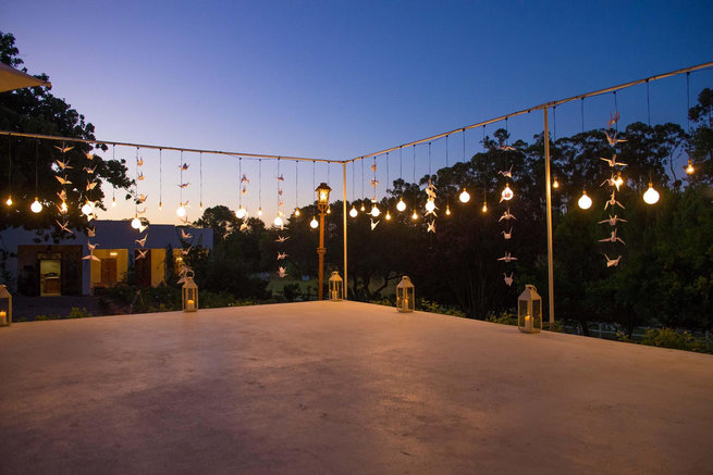 Naked bulbs on outdoor dancefloor / Langkloof Roses Wedding, Cape Town - Claire Thomson Photography