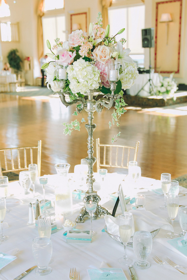 White hydrangea, cream and blush roses, white lillies, ivy wedding floral centerpiece