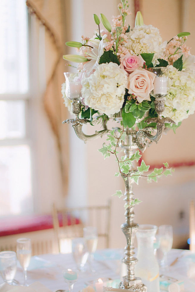 White hydrangea, cream and blush roses, white lillies, ivy wedding floral centerpiece
