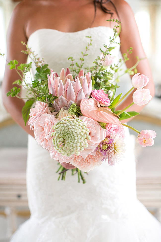 Breathtaking Wedding Bouquet Recipe: Pink King Protea, pink tulips, blush pink garden roses, pink lily, queen annes lace and greens. Click to blog for more gorgeous bouquet ideas. 