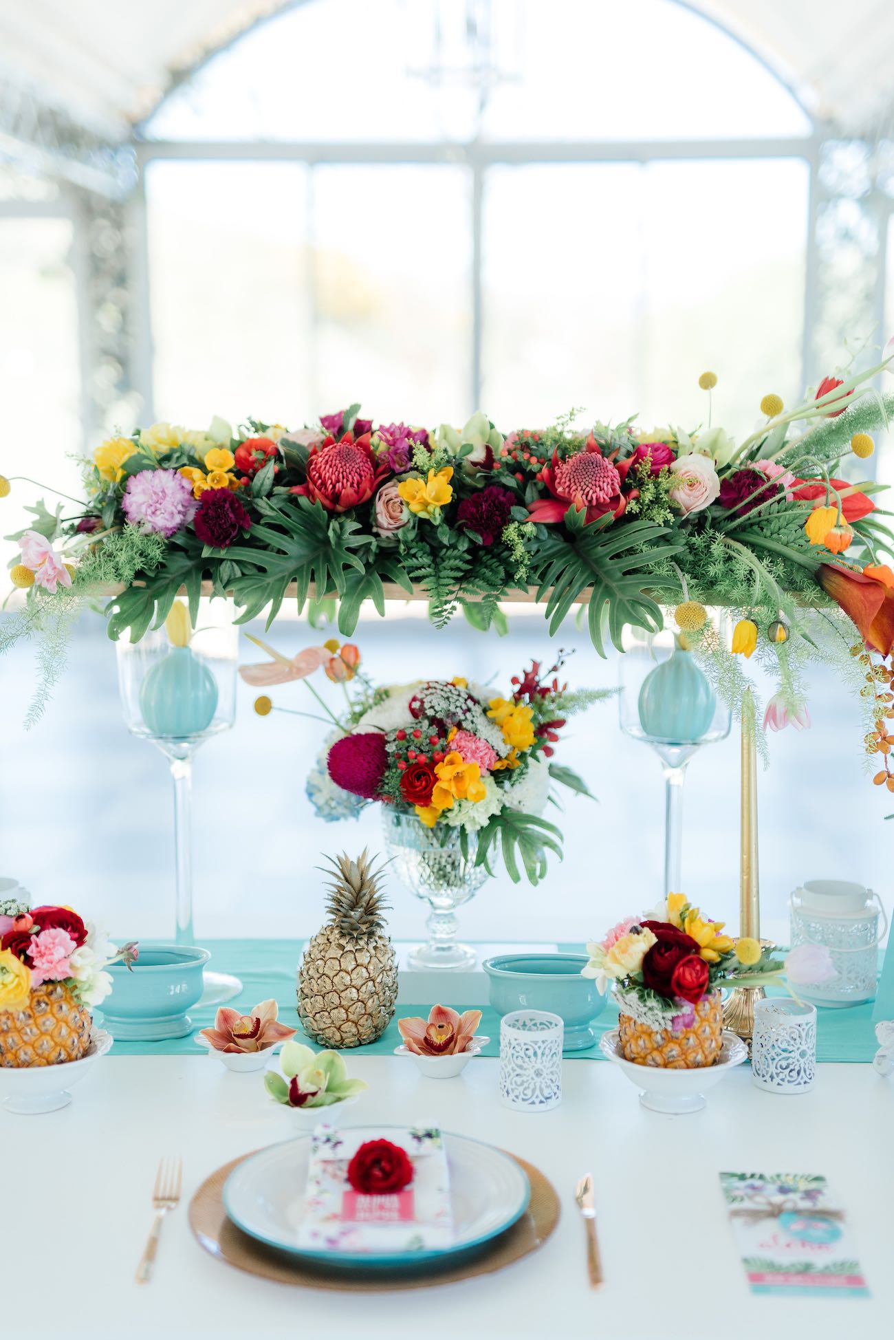 Ridiculously stunning, bright and beautifully tropical tablescape filled with flowers, ferns, pineapples and hand painted details. Click for the most absolutely gorgeous Tropical Wedding ideas ever!