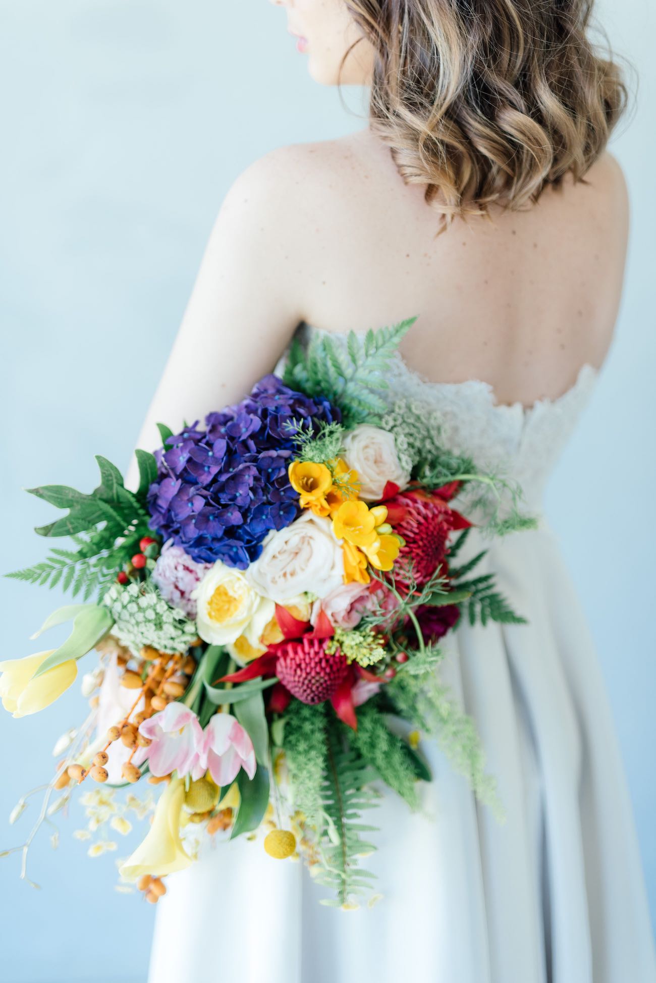 STUNNING tropical wedding bouquet made from a cascade of bright blue hydrangea, yellow lilies, ferns, tulips. roses, queen annes lace, billies balls, protea and beautiful blooms! Super cute "tutti frutti", Carmen Miranda style tropical flower crown for a tropical bride in bright colors. Fun and cute. Tropical Wedding Ideas photographed by Debbie Lourens Photography