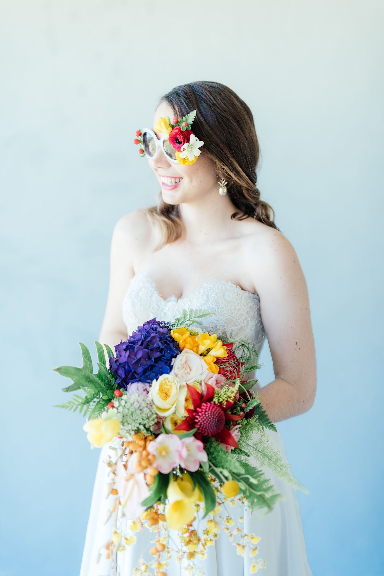 STUNNING tropical wedding bouquet made from a cascade of bright blue hydrangea, yellow lilies, ferns, tulips. roses, queen annes lace, billies balls, protea and beautiful blooms! Super cute "tutti frutti", Carmen Miranda style tropical flower crown for a tropical bride in bright colors. Fun and cute. Tropical Wedding Ideas photographed by Debbie Lourens Photography